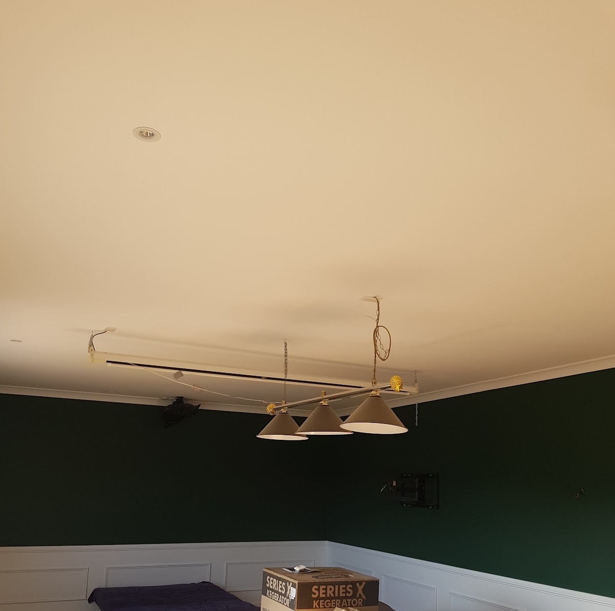 Finished ceiling above green walls, pendant lights ready to hang